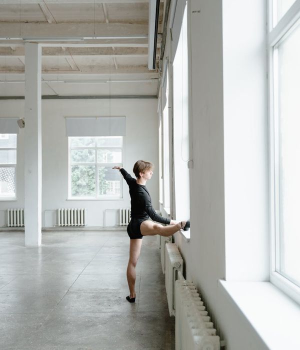 Man performing a controlled bodyweight exercise in a minimalist space.